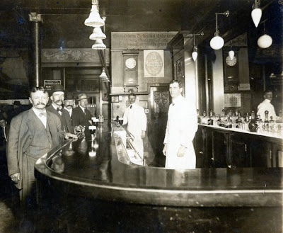 Josef Gartz (rear) working as Sandwich Man in Joe Nelson's Saloon, Northeast corner of Crawford [now Pulaski] and Madison Street, Chicago