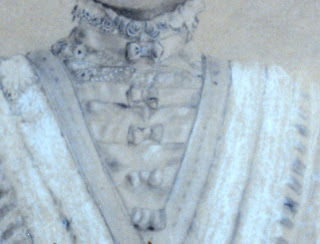 Detail: notice rosettes surrounding top of high-neck and overlapping material festooned with tiny bows.
