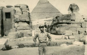 Handsome World War II navigator stands with hands on hips in front Egyptian Pyaramid